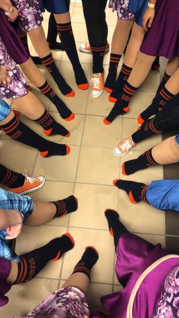 Student feet pointed in circle showing off custom socks